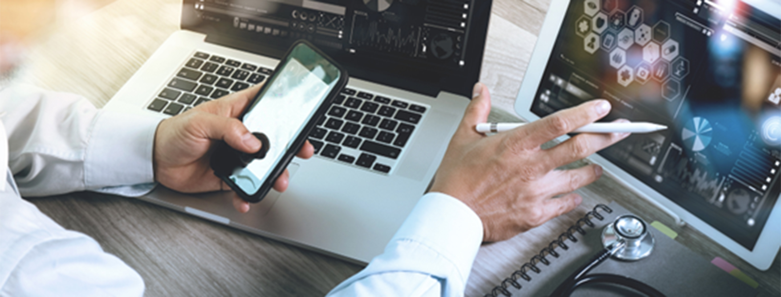man working on two laptops