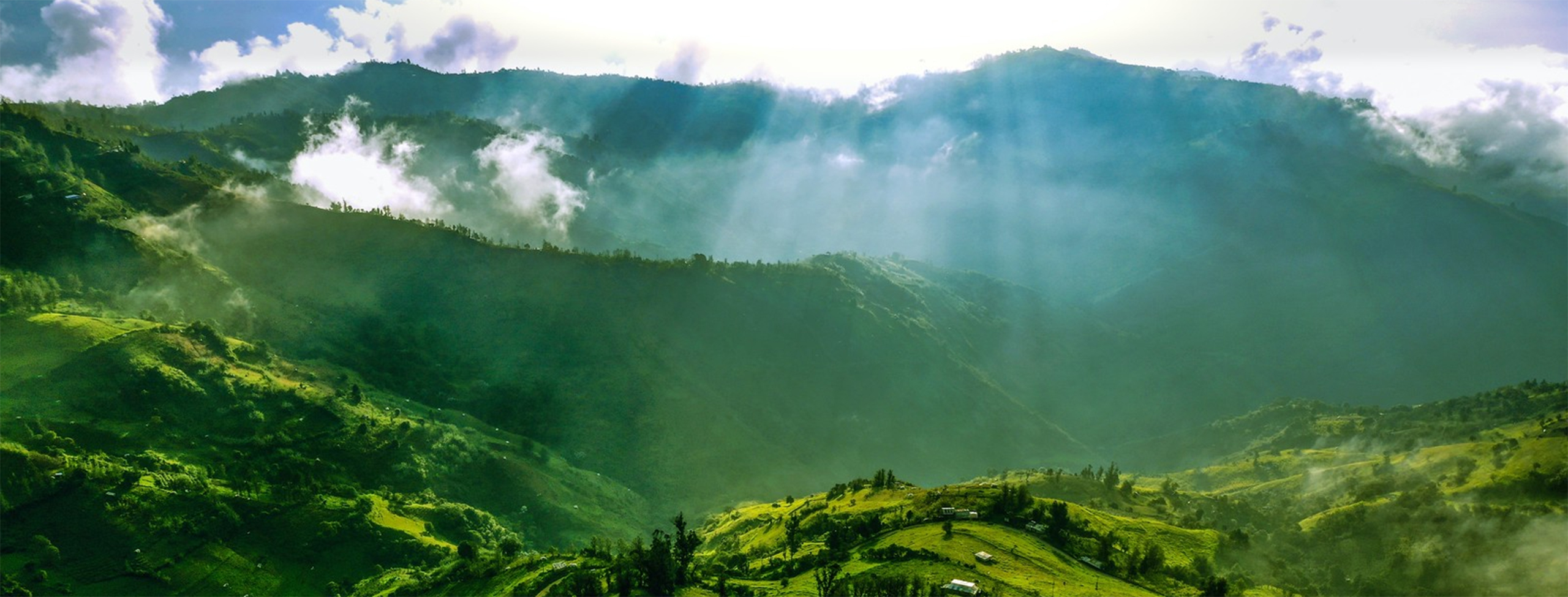 Sunbeams illuminating green hills