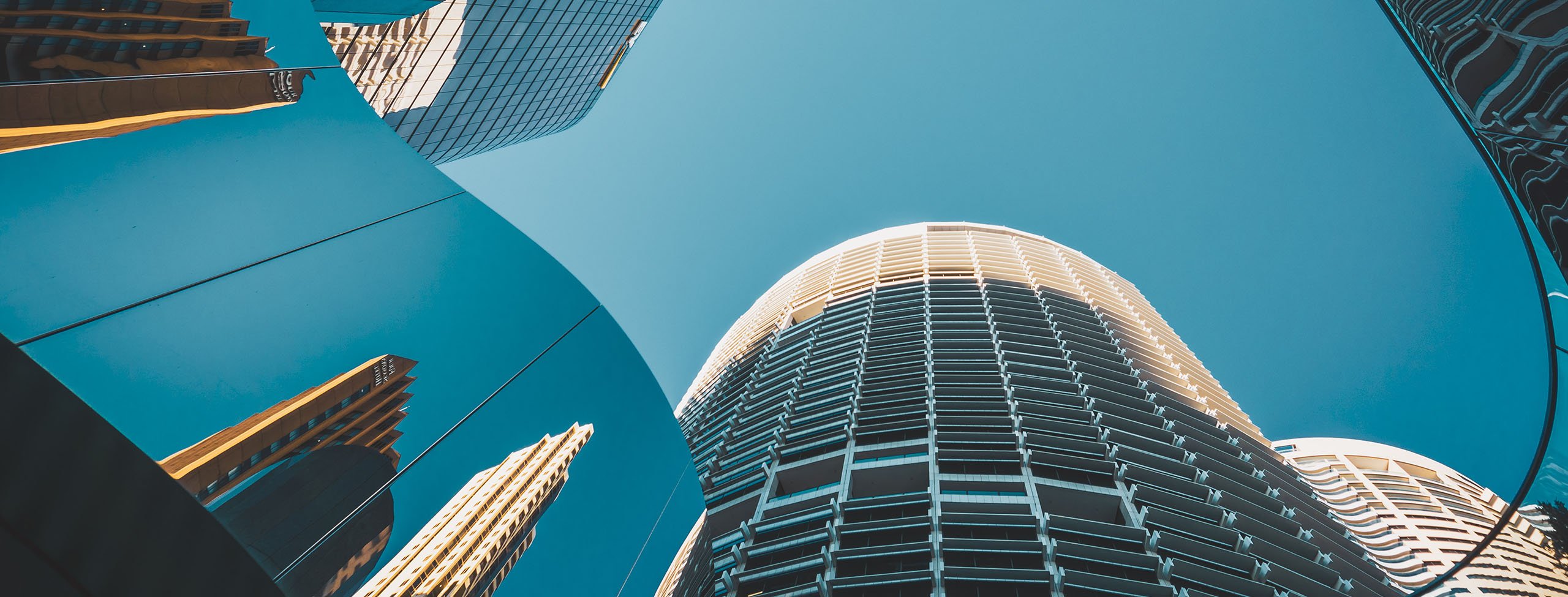 Low angle photo of mirror high rise buildings 2560x975