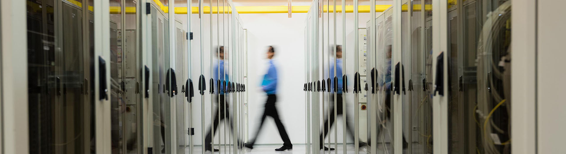 Technician walking in hallway of server room_PPT