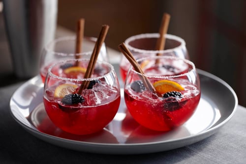A tray with four cups of blackberry cider