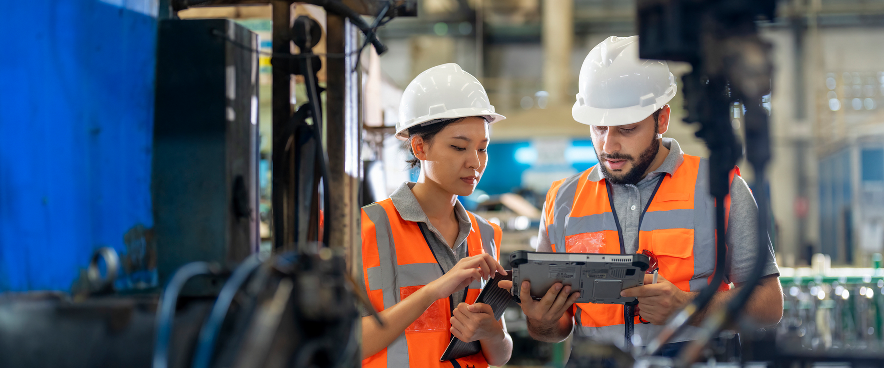 man and woman manufacturing employees looking at tablet