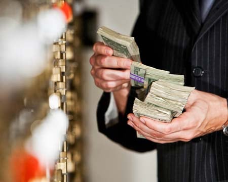Man with cash by safety deposit boxes