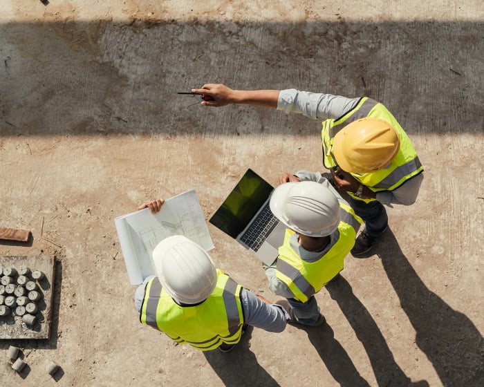 engineers reviewing plans on laptop