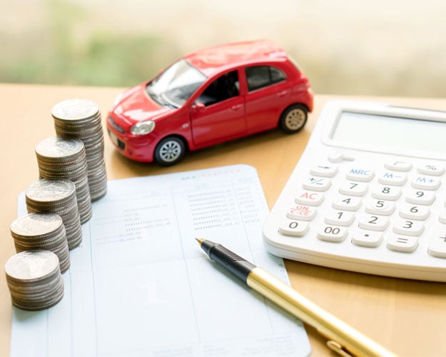 Coins stack in columns on saving book and car