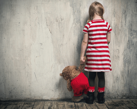 sad-girl-with-a-toy-bear-standing-back