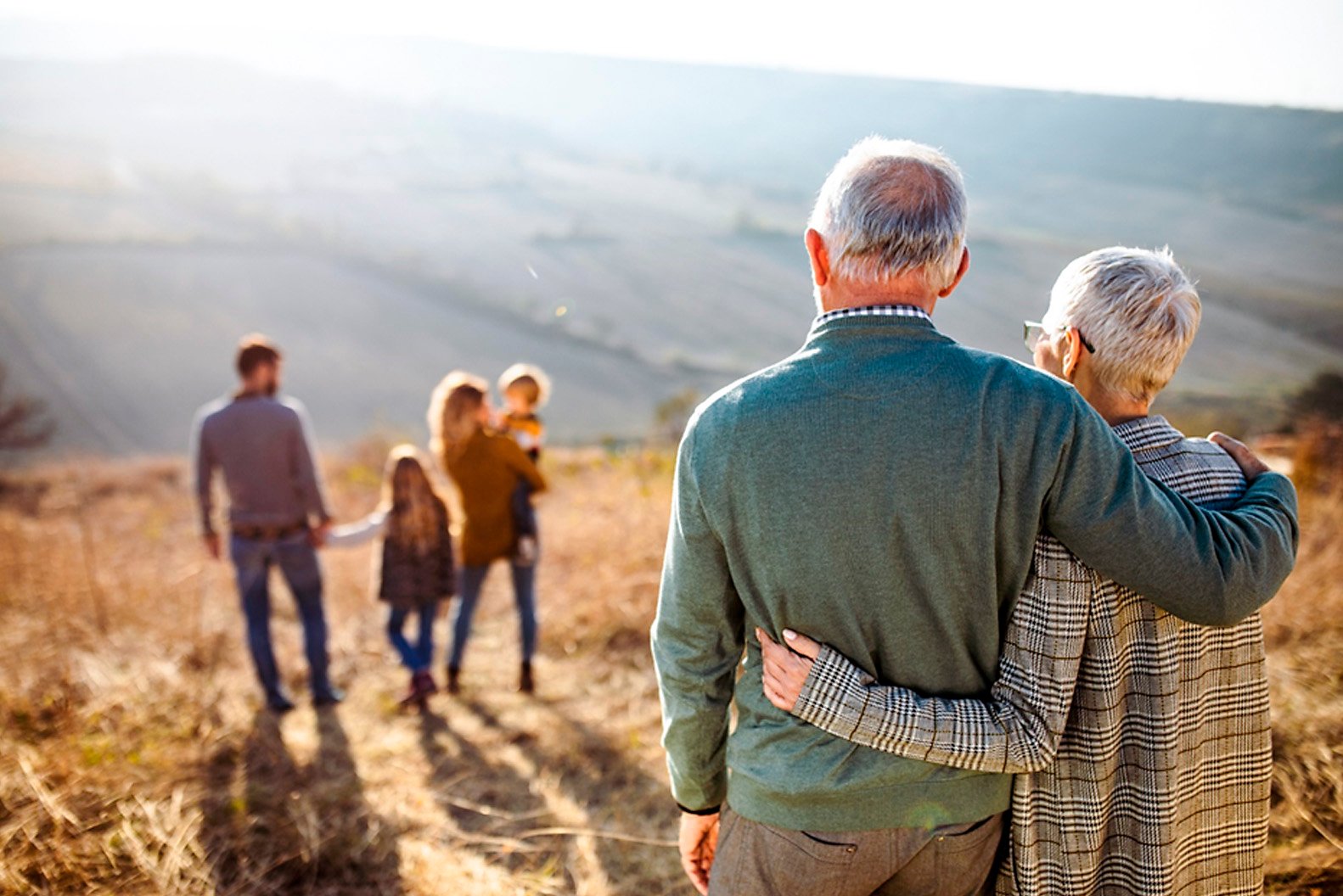 Grandparents hugging while looking at family