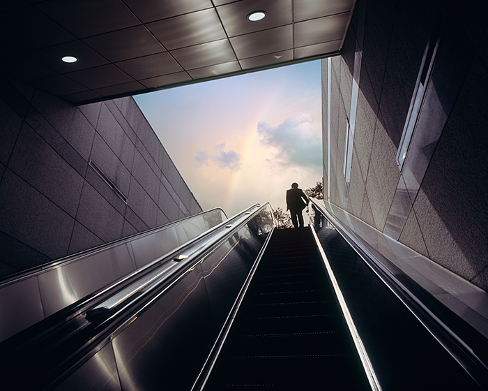 person going up escalator 