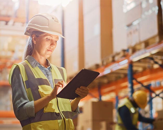 woman checking status in warehouse