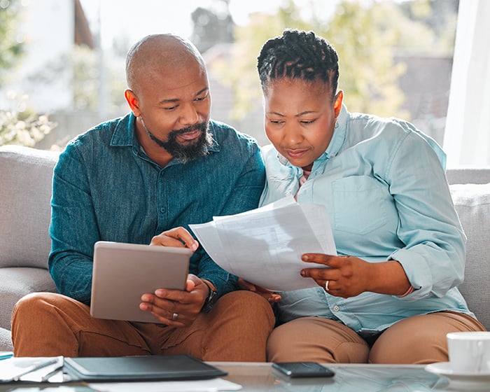 couple looking at papers and tablet
