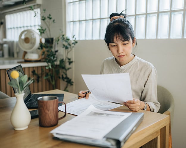 woman looking at and filling out paperwork