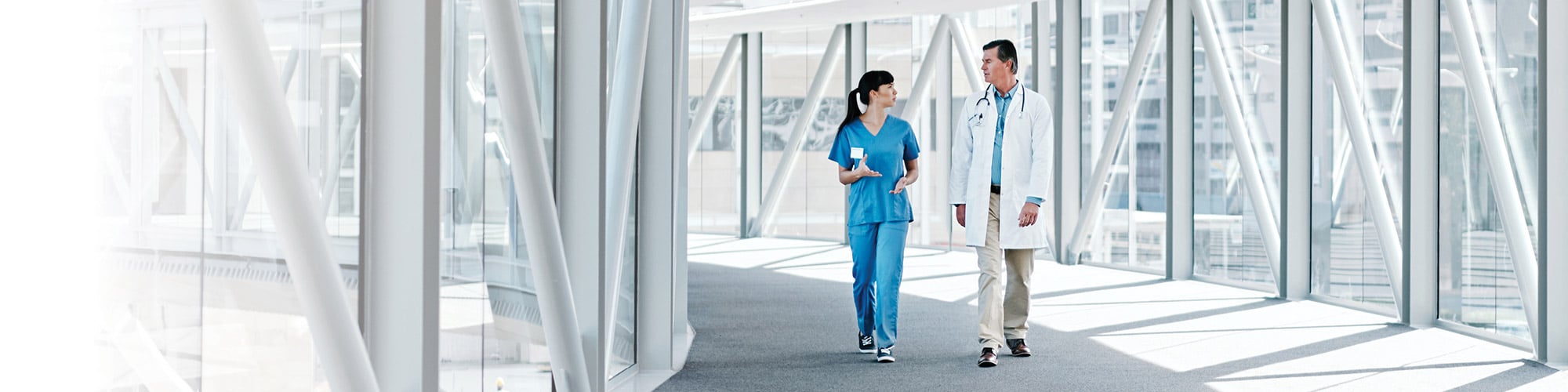 Doctor and Nurse walking and talking down a hall