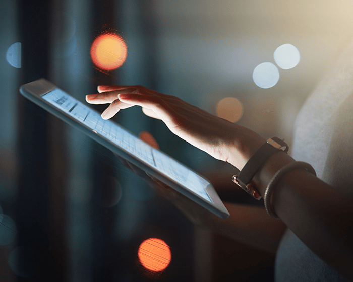 Cropped shot of an unrecognizable businesswoman using a digital tablet while working late