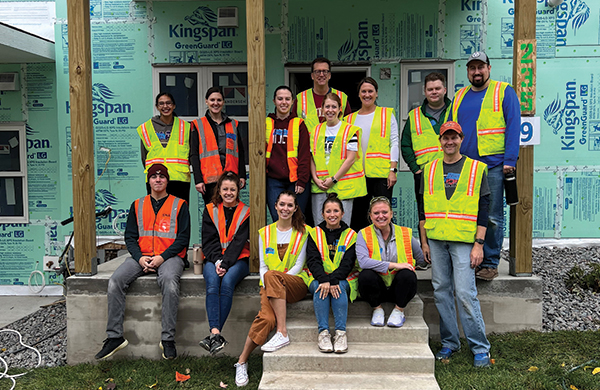 employees sitting outside of a home under construction