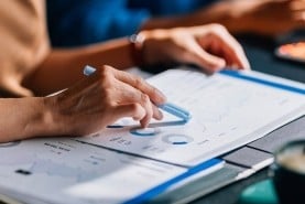 someone pointing to printed out dashboard