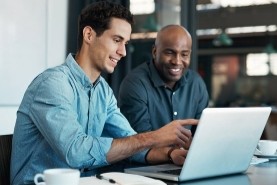 two coworkers working on a laptop