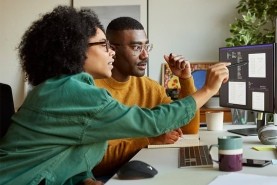 two coworkers looking at a computer screen
