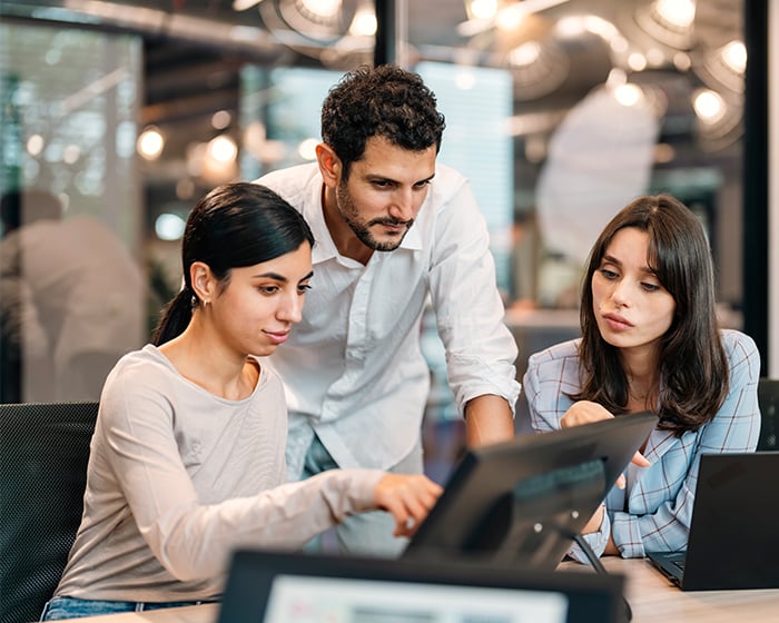 three coworkers working on a computer together