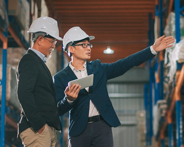 two men in warehouse wearing hardhats