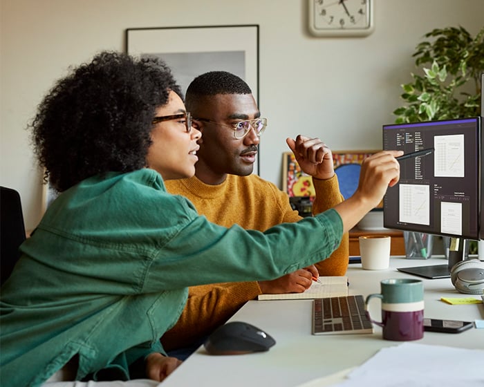 woman and man working together at a computer