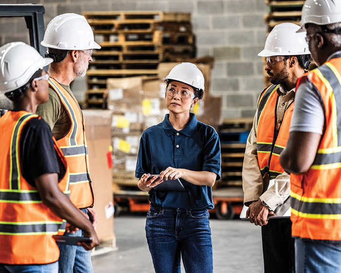 manufacturing employees in a meeting wearing hard hats