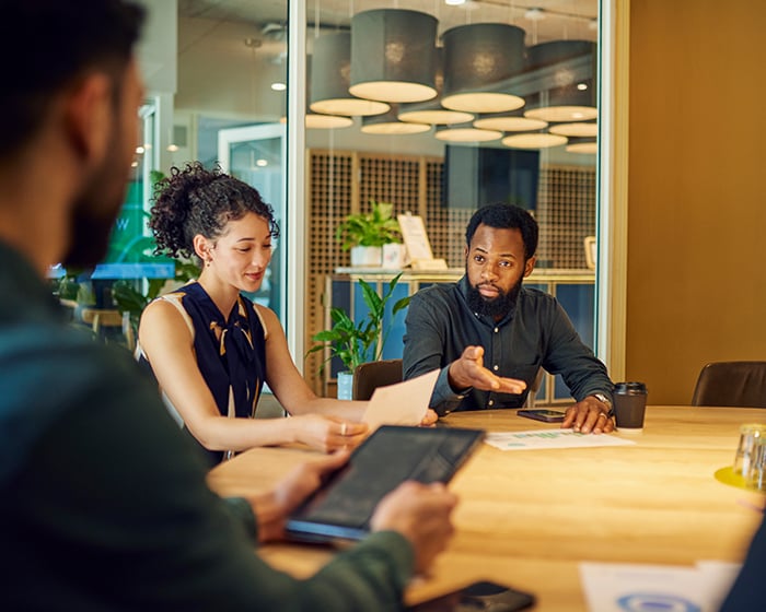 three people talking in a meeting