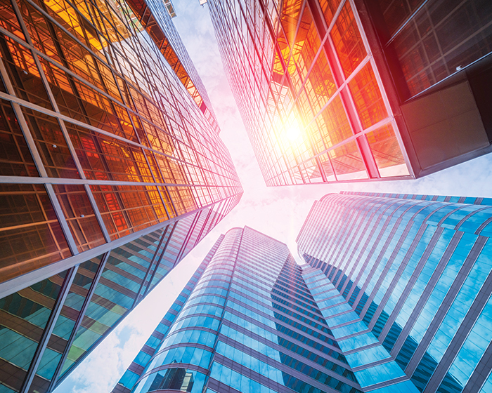 looking up at tall colorful glass buildings against the sky
