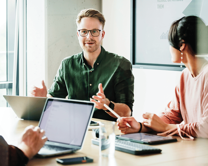 three coworkers discussing something during a meeting