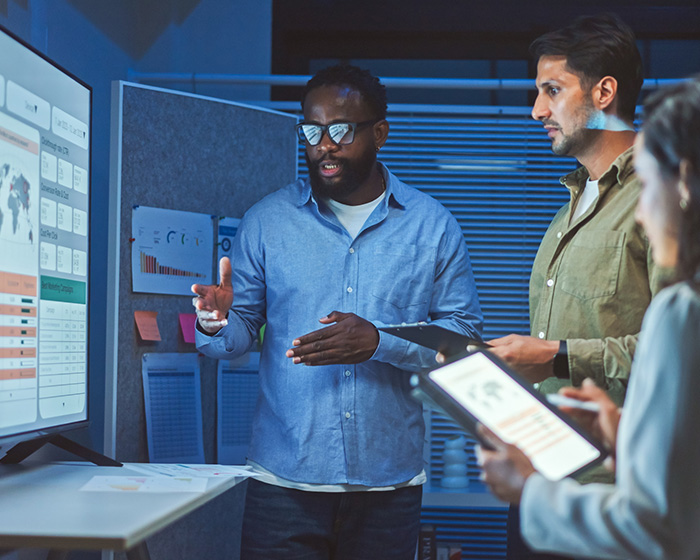 employees in a meeting looking at key risk indicators on a screen