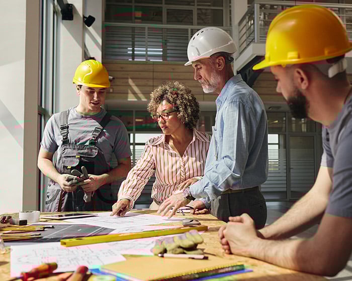 Group of people reviewing plans for an interior renovation of an office.