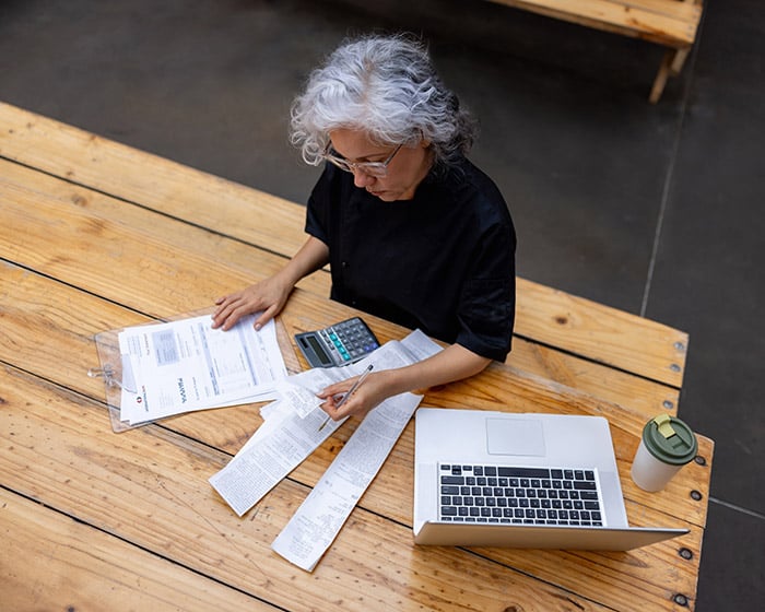 Woman sitting at a table looking at papers
