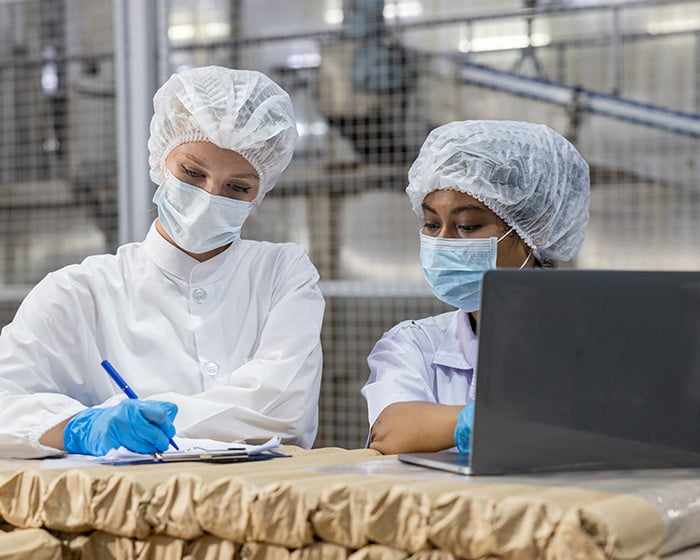 two employees in a food manufacturing facility