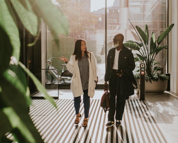 Two executives walking into an office while talking