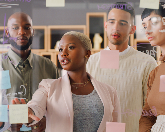 coworkers workshopping ideas with post it notes