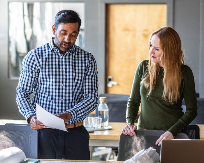 two coworkers looking at a piece of paper