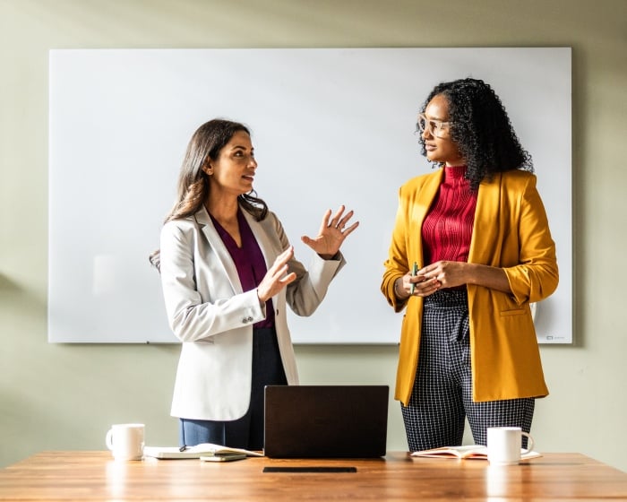 Two women talking in a conference room