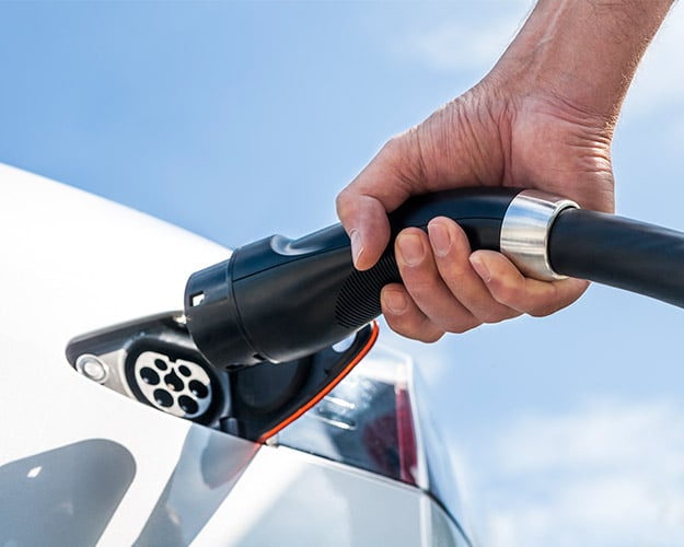 Man plugging in his electric vehicle.