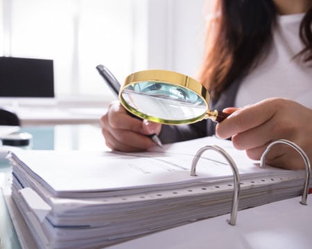 Businesswoman Checking Bill Through Magnifying Glass