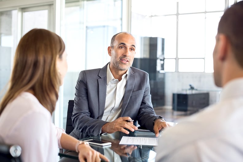 Man talking to two people in a meeting