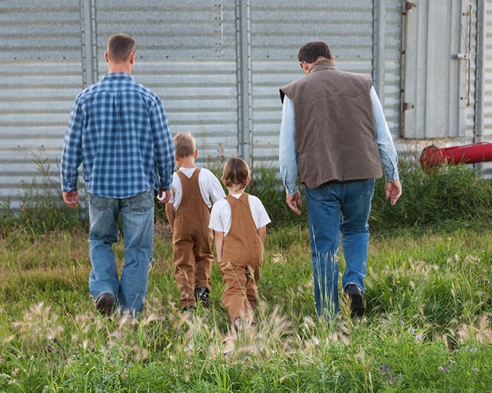 Two farmers walking with 2 children