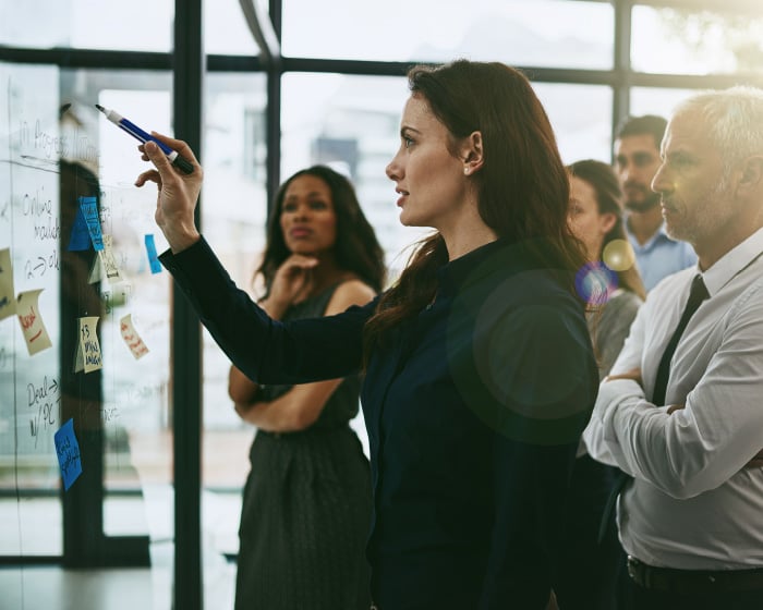 woman writing on board during meeting