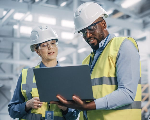 two people using computer in warehouse