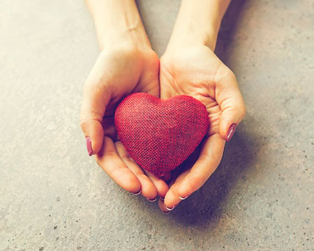 Female hands giving red heart