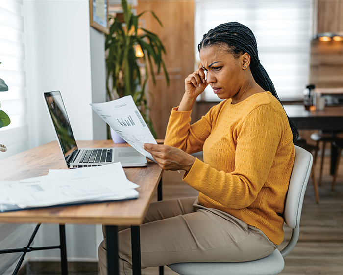 woman looking at piece of paper confused
