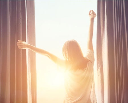 woman-waking-up-to-sunshine