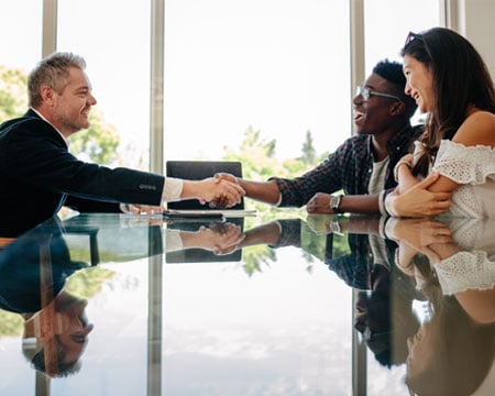 Estate-agent-congratulating-couple