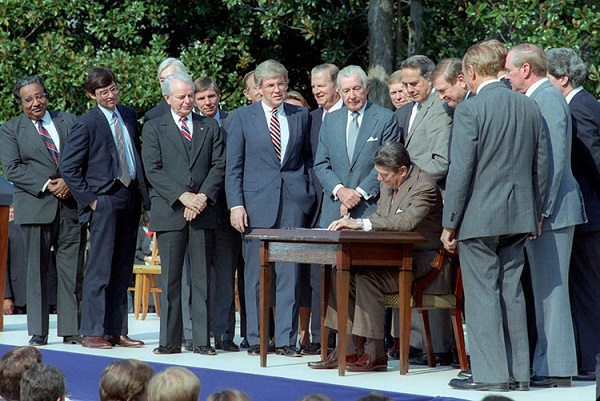 President Reagan signs TRA 1986. Image via Reagan Library.