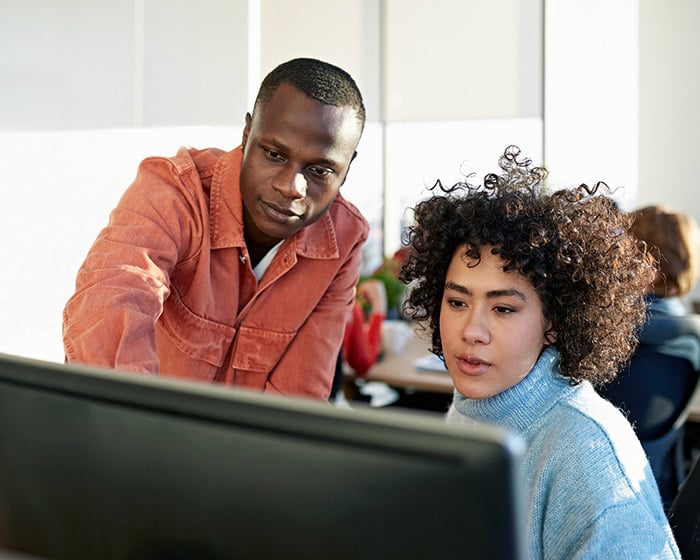 Man showing woman something on the computer