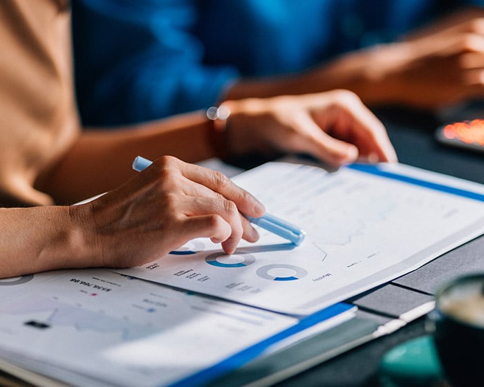 person pointing to a chart or data with a pen