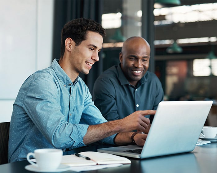 two men working on a laptop computer